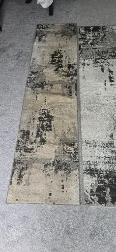 Full abstract patterned rug laid out on a grey carpet